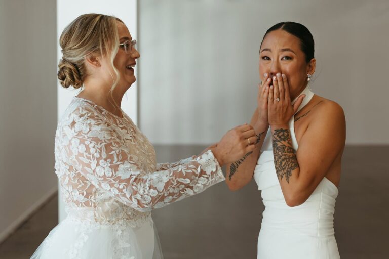 One bride covers her mouth with her hands, visibly emotional during the first look.