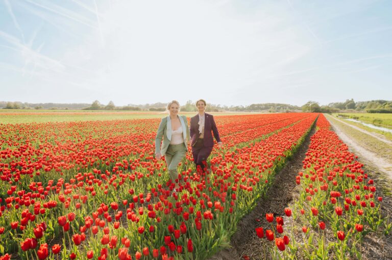 Queer couple walking through tulip fields in Amsterdam