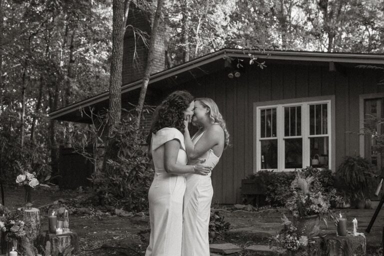 Brides sharing first kiss at outdoor ceremony