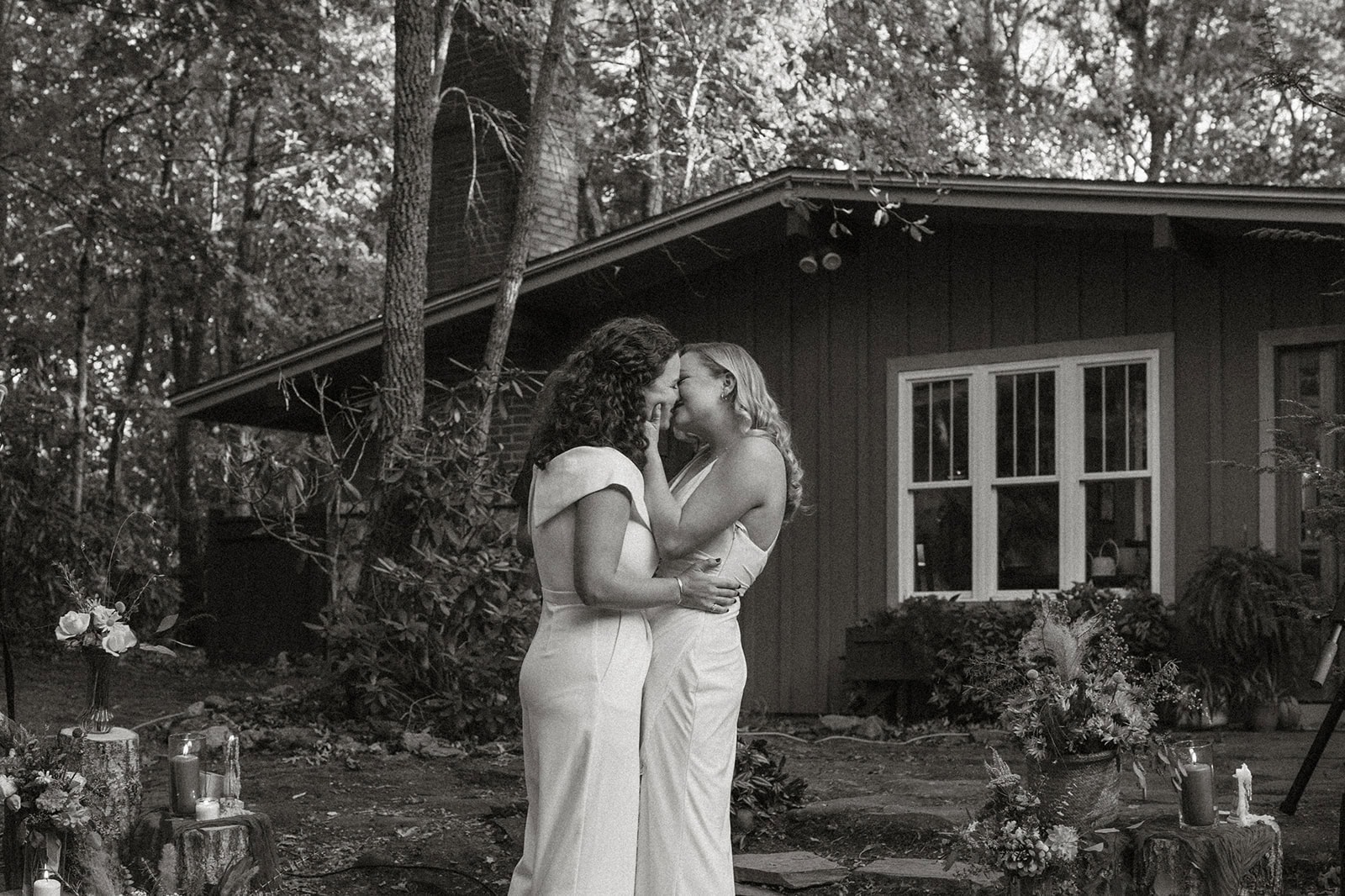 Brides sharing first kiss at outdoor ceremony