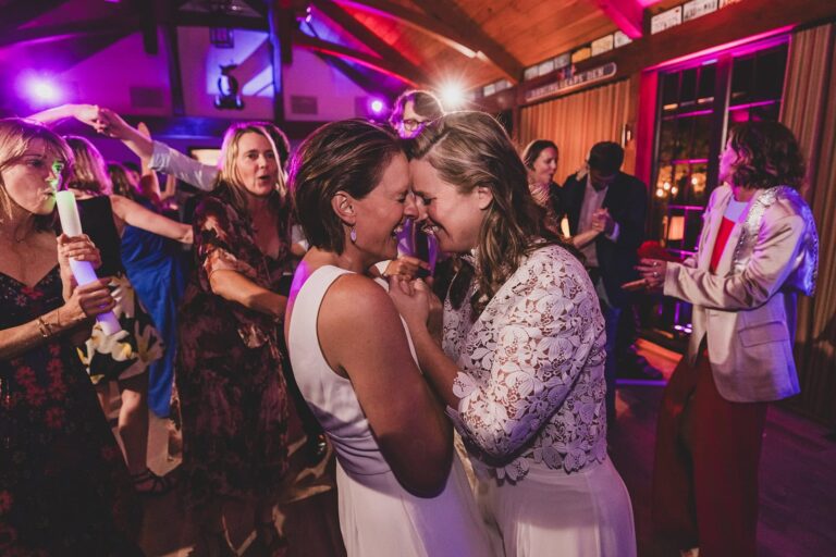 Brides dancing closely on crowded reception floor