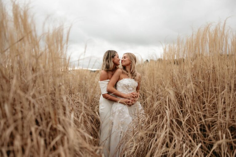 Brides embracing in golden grass at Bendooley Estate