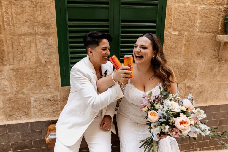 Couple celebrating with Kinney drinks and bouquet in Malta